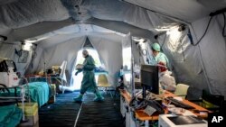 Le personnel médical à l'intérieur d'une des structures d'urgence qui ont été mises en place pour faciliter les procédures à l'extérieur de l'hôpital de Brescia, en Italie, le mardi 10 mars 2020. (Claudio Furlan/LaPresse via AP)