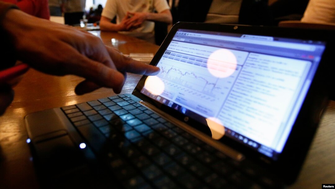FILE - A man checks the graph showing recent fluctuations on Bitcoin exchange rates against the U.S. dollar on his laptop during a media opportunity at the Tokyo Bitcoin weekly meeting at a restaurant in Tokyo.