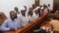 Murder suspects in the killing of Ugandan Police Commander Andrew Felix Kaweesi stand behind the dock at the Nakawa Chief Magistrates court in Kampala, Uganda, May 18, 2017. (H. Athumani/VOA)