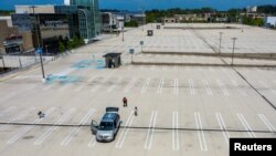 La familia juega al frisbee en un estacionamiento vacío al lado del King of Prussia Mall, que permanece cerrado debido al brote continuo de la enfermedad por coronavirus (COVID-19) en Upper Merion Township, Pensilvania, Estados Unidos, 21 de mayo de 2020.