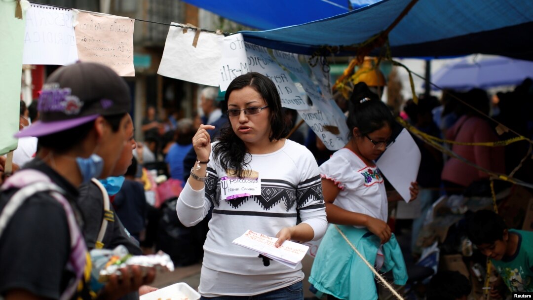 Psychologist Mayra Campos talks to a couple in a provisional camp after an earthquake in Xochimilco on the outskirts of Mexico City, Mexico, Sept. 25, 2017.