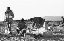 FILE - Technicians of the U.S. Air Force use rubber gloves while picking up pieces of the wreckage and placing them in cardboard boxes in Palomares, Spain, Jan. 28, 1966.