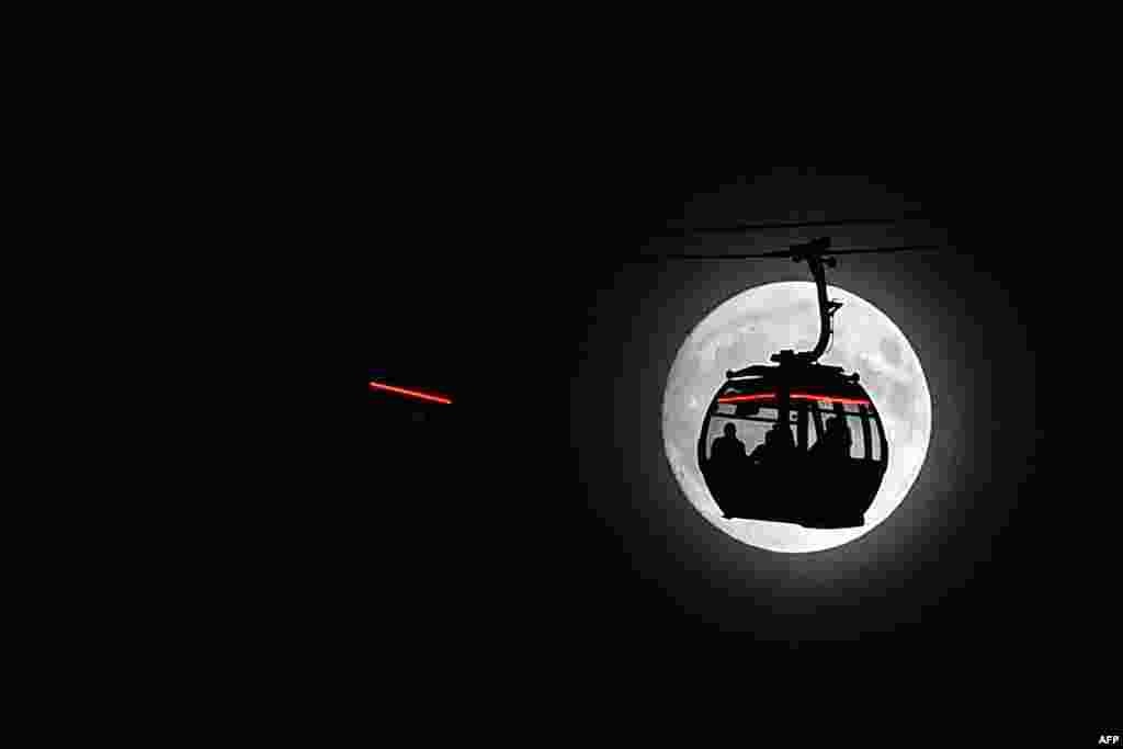 영국 런던 더크랜즈의 케이블카 뒤로 보름달이 떴다. 1948년 이후 달의 궤도가 지구에 가장 가까이 접근하면서, 68년 만에 가장 크고 밝은 '슈퍼문'을 관측할 수 있다.