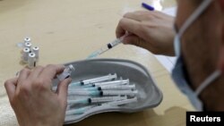 A medical worker prepares a dose of the "Comirnaty" Pfizer-BioNTech COVID-19 vaccine during the operation "5000 vaccines in one day and on a single site" in Nice as part of the coronavirus disease (COVID-19) vaccination campaign in France, April 9, 2021. 