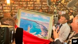 Rais wa Ufaransa Emmanuel Macron, wa pili kulia, akizindua mchoro unaoonyesha mji wa Oran. (AP Photo/Oleg Cetinic).

