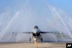 FILE - A U.S.-made F-16V fighter jet is cleaned by an auto washing machine during a military exercise in Chiayi County, southern Taiwan, Jan. 15, 2020.