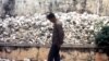 FILE - A Cambodian man is seen at one of the Killing Fields where vast numbers of people were killed by the Khmer Rouge regime.