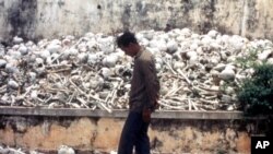 FILE - A Cambodian man is seen at one of the Killing Fields where vast numbers of people were killed by the Khmer Rouge regime.