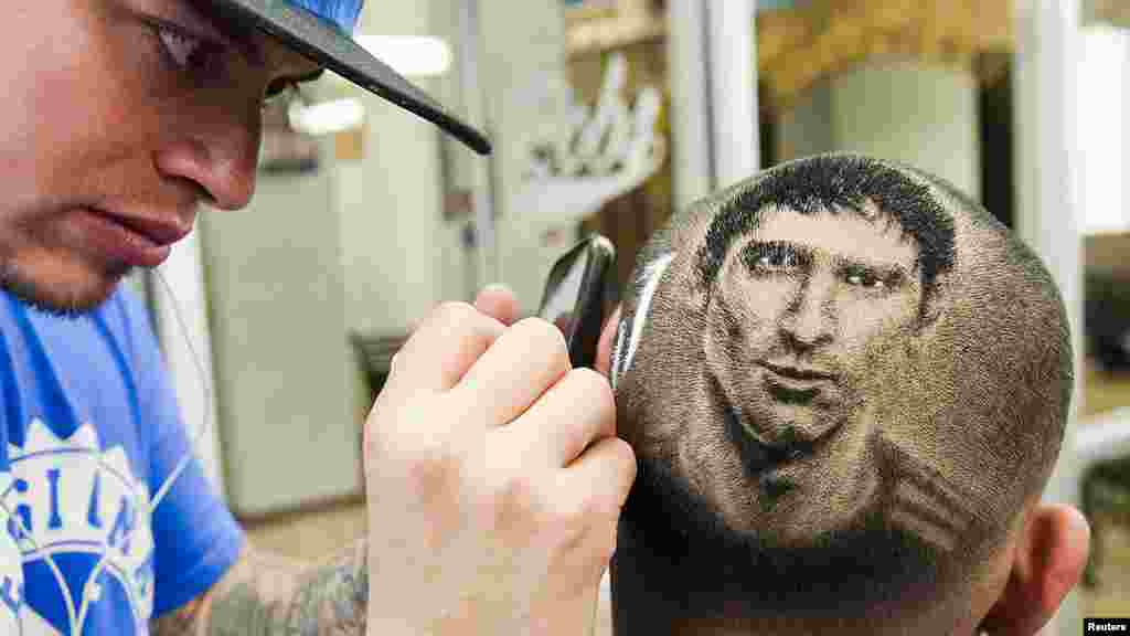 Seniman pangkas rambut membentuk gambar Lionel Messi pada kepala seorang penggemar di San Antonio, Texas, AS.