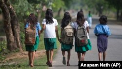 Indian girls walk to a school at Burha Mayong village about 45 kilometers (28 miles) east of Gauhati, India, Thursday, April 9, 2015. 