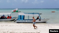 FILE - A tourist runs along a deserted beach near the Indian Ocean in the Kenyan coastal city of Mombasa in this 2012 photo. 