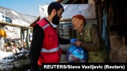 Aktivista Crvenog krsta dostavlja pomoć starijim građanima (Foto: REUTERS/Stevo Vasiljevic)