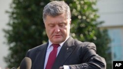 Ukrainian President Petro Poroshenko checks his watch while speaking to members of the media outside the West Wing of the White House, following his meeting with President Barack Obama, Sept. 18, 2014.