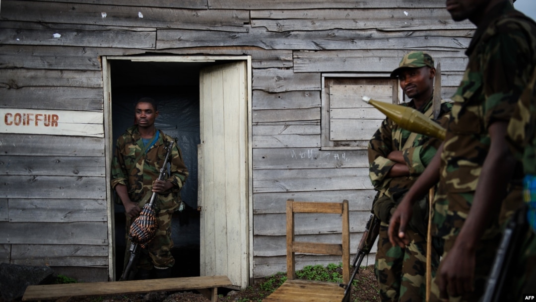 Para pejuang pemberontak M23 berdiri di luar rumah kayu di desa Kanyarucinya, 6 kilometer dari Goma, di wilayah timur Republik Demokratik Kongo (DRC) (18/11).