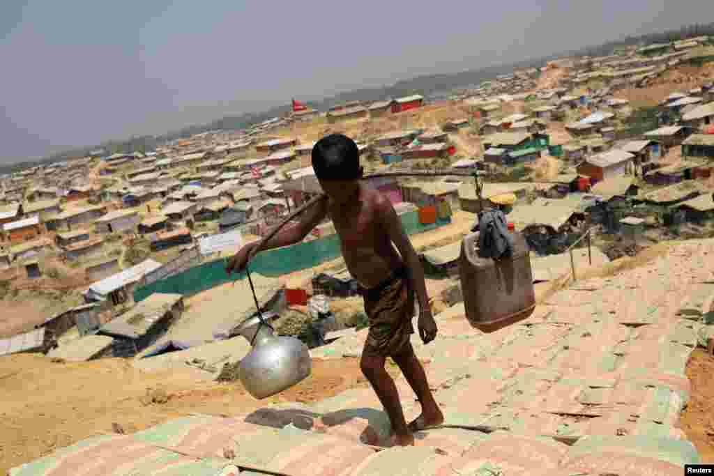 Um rapaz refugiado Rohingya carrega água no campo de refugiados Kutupalong, em Cox&#39;s Bazar, Bangladesh, Março 22, 2018.