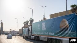 A convoy of trucks loaded with aid supplies for Gaza provided by Egyptian NGOs waits for an agreement to cross through the Egypt-Gaza border in Arish City in Egypt’s north Sinai Peninsula on Oct. 15, 2023.