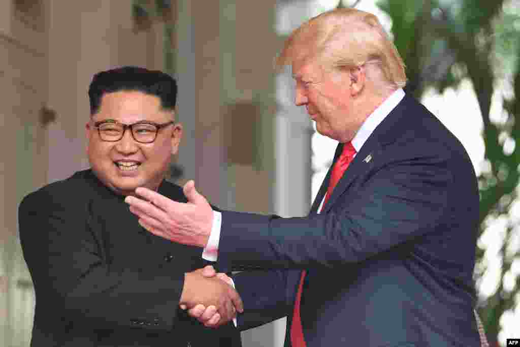 President Amerika Serikat Donald Trump (kanan) berjabat tangan dengan pemimpin Korea Utara Kim Jong Un dalam pertemuan bersejarah antara Amerika Serikat dan Korea Utara di Hotel Capella, Singapura.(Foto: AFP)