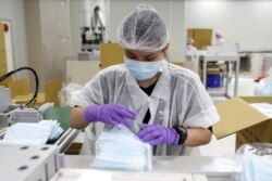 A worker packs surgical masks on the production line in a factory in Taoyuan, Taiwan, April 6, 2020.