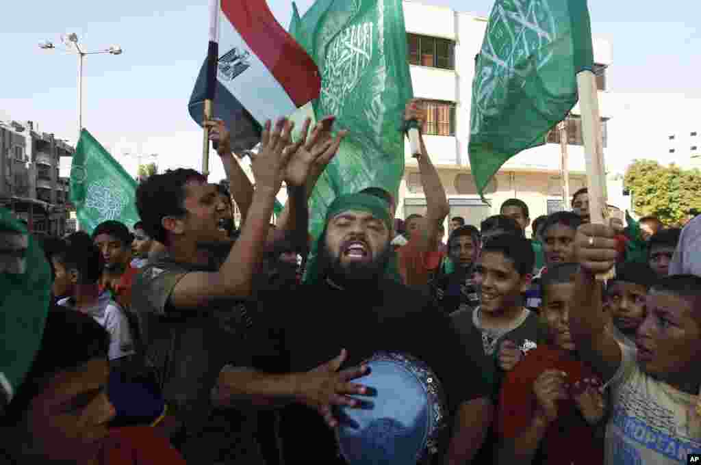 Palestinians wave green Islamic flags that represent Hamas and the Egyptian national flag as they celebrate the victory of Mohammed Morsi in the Egyptian presidential elections, in Gaza City, June 24, 2012. (AP)