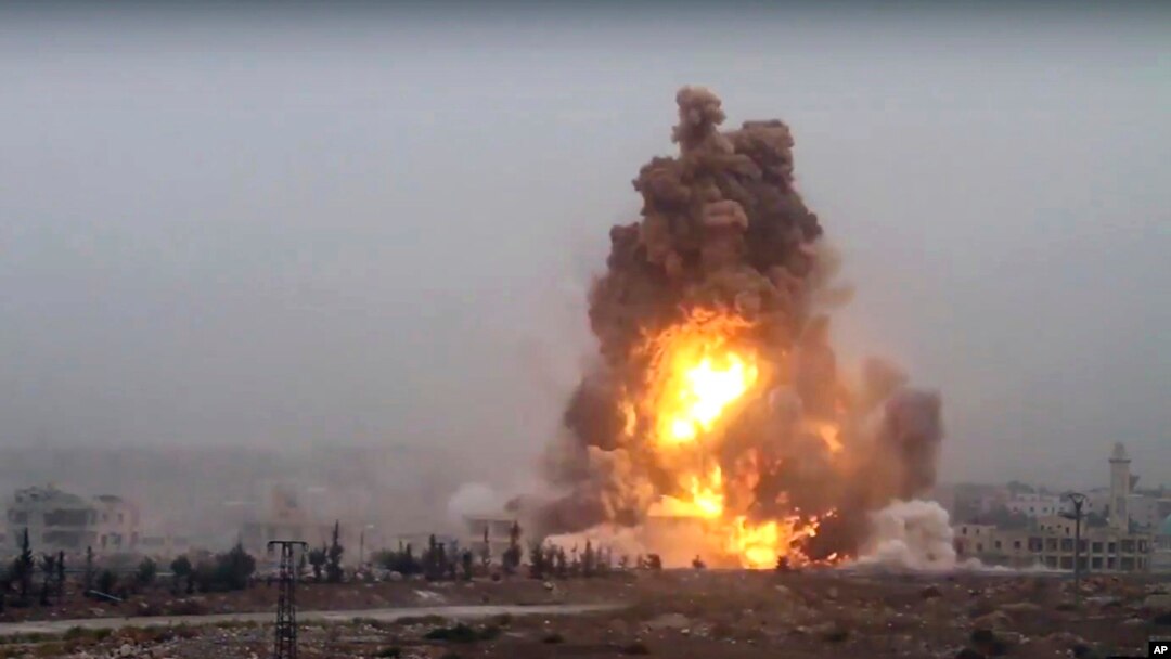 This frame grab from video provided by Thiqa news agency, a Syrian opposition media outlet that is consistent with independent AP reporting, shows flames rises from an explosive vehicle bomb that attacked a Syrian government position, in southwest of Alep