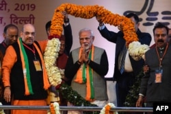 FILE - Indian Prime Minister Narendra Modi, center, is garlanded by BJP leaders on the first day of the two-day Bharatiya Janata Party national convention in New Delhi, Jan. 11, 2019.