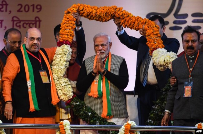 FILE - Indian Prime Minister Narendra Modi, center, is garlanded by BJP leaders on the first day of the two-day Bharatiya Janata Party national convention in New Delhi, Jan. 11, 2019.