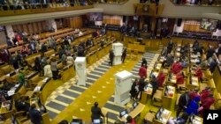 FILE - Members of parliament prepare to vote for or against the motion of no confidence against South African president, Jacob Zuma in the South African parliament in Cape Town, South Africa, Aug. 8, 2017.