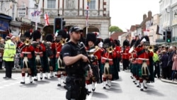 Armed police stand guard as the Royal Regiment of Scotland band march by in Windsor, south England, May 7, 2019, a day after Prince Harry announced that his wife Meghan, Duchess of Sussex, had given birth to a boy.