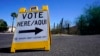 ARCHIVO - Un cartel marca la entrada a un distrito electoral en el primer día de votación anticipada para las elecciones generales en Phoenix, el 12 de octubre de 2022.