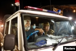 Seorang imigran India yang dideportasi dari Amerika Serikat duduk di dalam kendaraan polisi saat meninggalkan bandara di Amritsar, India, 5 Februari 2025. (Adnan Abidi/REUTERS)