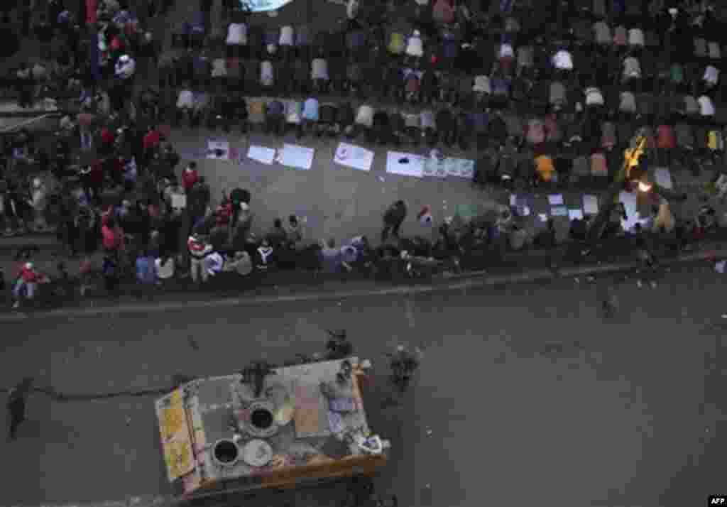 Anti-government protesters pray near Egyptian solders in Tahrir, or Liberation Square in Cairo, Egypt, Tuesday, Feb. 1, 2011. More than a quarter-million people flooded into the heart of Cairo Tuesday, filling the city's main square in by far the largest