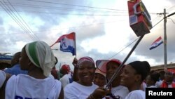 FILE - Supporters of Ghana opposition leader Nana Akufo-Addo wave boxes of Kalyppo juice in Accra, Ghana, Oct. 11, 2016. 