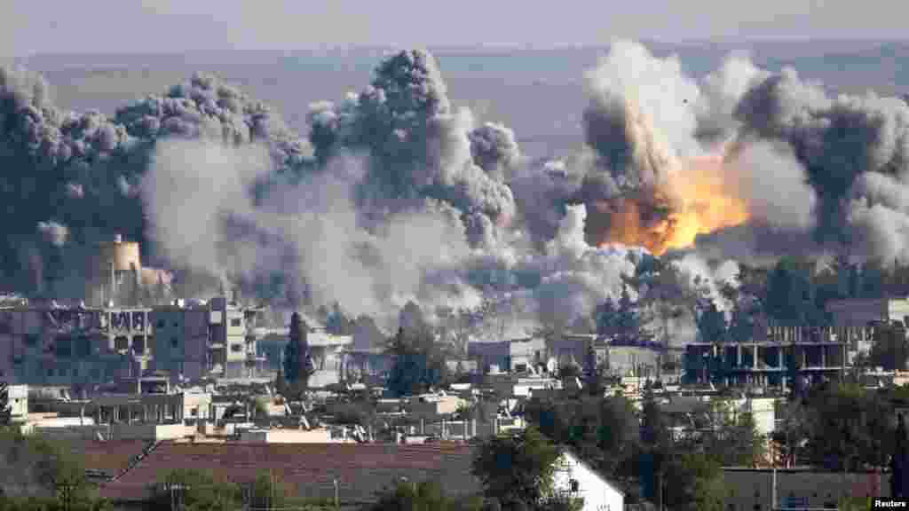 Smoke rises over Syrian town of Kobani after an airstrike, as seen from the Mursitpinar border crossing on the Turkish-Syrian border in the southeastern town of Suruc, in Sanliurfa province, Oct. 18, 2014. 