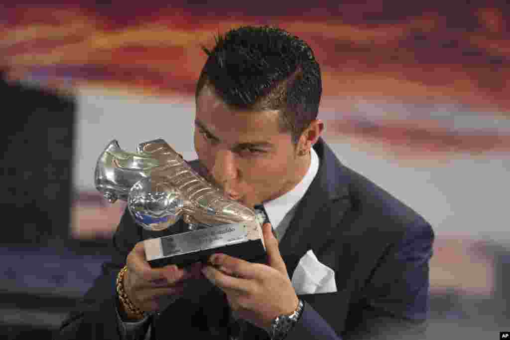 Real Madrid&rsquo;s striker Cristiano Ronaldo kisses a silver boot award for scoring the most goals for the club during a ceremony at the Santiago Bernabeu stadium in Madrid, Spain. Ronaldo recently overtook Raul Gonzalez to become the club&#39;s all-time highest goalscorer with a tally of 324 goals.