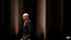 Mantan menteri luar negeri AS Colin Powell tampak berjalan di atas panggung dalam sebuah seminar di Tokyo, Jepang, pada 18 Juni 2014. (Foto: AP/Eugene Hoshiko)