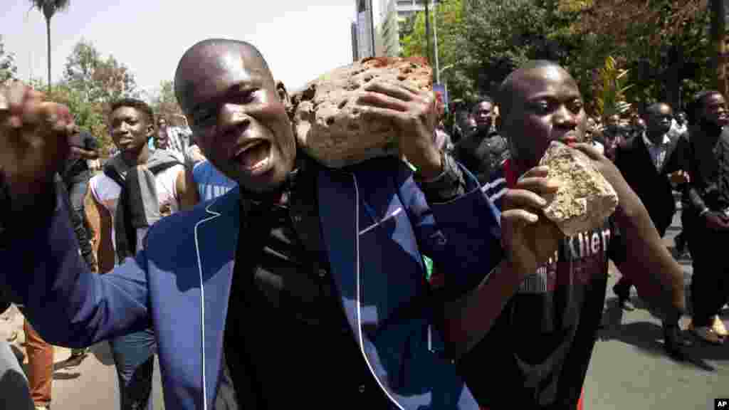 University students carry stones to block roads on the main Uhuru Highway, during a demonstration in Nairobi, Kenya, Tuesday, Sept, 22, 2015. 