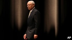 Former U.S. Secretary of State Colin Powell walks in the stage to speak during a seminar in Tokyo, June 18, 2014