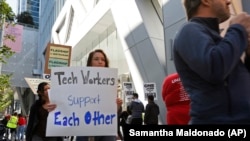 In this photo taken July 16, 2019, tech workers march to support Facebook's cafeteria workers, who were rallying for a new contract with their company Flaghship in San Francisco. (AP Photo/Samantha Maldonado)