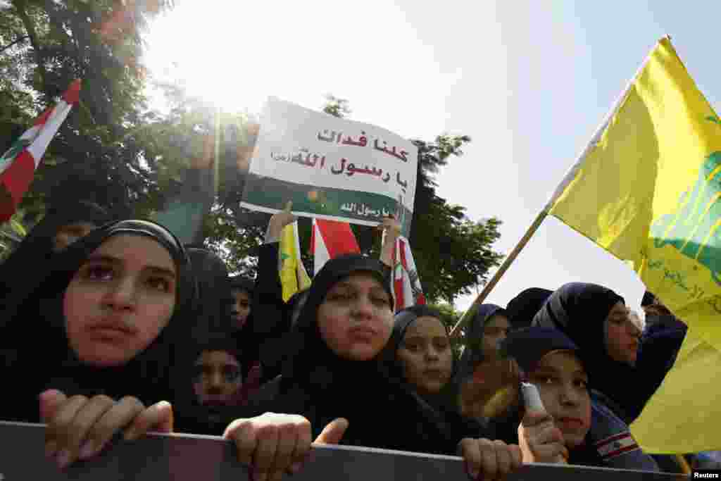 Girls from Lebanon's Hezbollah Scouts wave Hezbollah and Lebanese flags and a sign saying "We sacrifice ourselves for you, Prophet of God" during a protest against the film made in the U.S. that mocks Prophet Mohammad in Beirut September 28, 2012. 