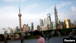 A man looks at his iPad in front of the financial distric in Shanghai on Sept. 24, 2013.