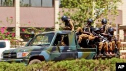 FILE - Troops ride in a vehicle near the French Embassy in central Ouagadougou, Burkina Faso, March 2, 2018.