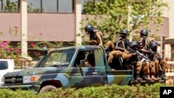 Troops ride in a vehicle near the French Embassy in central Ouagadougou, Burkina Faso, March 2, 2018, after an attack on the facility and two others.