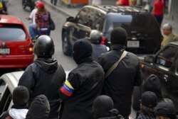 Masked members of a "colectivo" -pro-government cells- attend a rally in Caracas on Jan. 7, 2019.