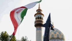 Iranci podižu zastavu i maketu projektila tokom proslave nakon napada iranskih raketa i dronova na Izrael, 15. aprila 2024. na Trgu Palestina u centru Teherana.