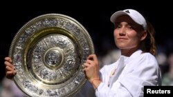 FILE: At Wimbledon, Kazakhstan's Elena Rybakina poses with the trophy after winning the women's singles final against Tunisia's Ons Jabeur, the first African woman to reach the storied tournament's finals. 7.9.2022