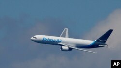 FILE - A Boeing 767 with an Amazon.com "Prime Air" livery flies over Lake Washington, Aug. 5, 2016. 