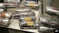 (FILE) This photo provided by U.S. Customs and Border Protection shows 16 packages of methamphetamine and heroin found in a car at the U.S.-Mexico border port of entry in Nogales, Ariz on June 10, 2015.