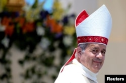 FILE - Bishop Juan Barros looks on as Pope Francis leaves at the end of a mass at the Lobito beach in Iquique, Chile, Jan. 18, 2018.