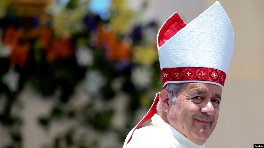 FILE - Bishop Juan Barros looks on as Pope Francis leaves at the end of a mass at the Lobito beach in Iquique, Chile, Jan. 18, 2018. 