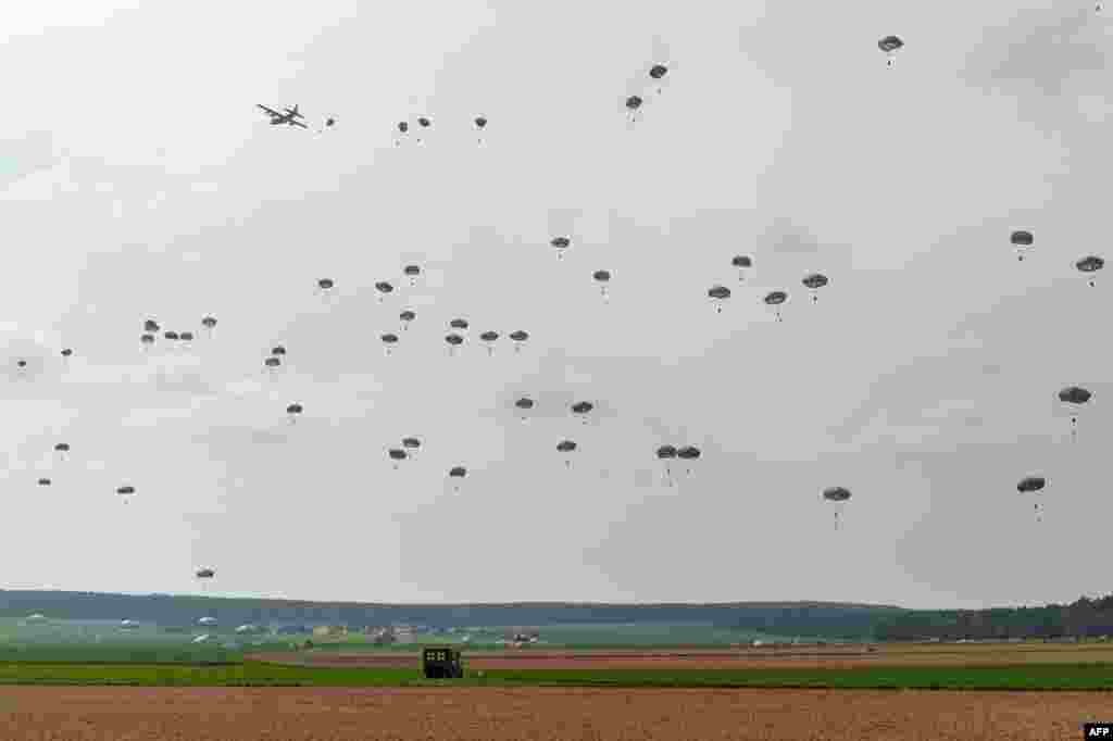 Parachutists land on a field near Burglengenfeld, southern Germany. Soldiers from the U.S., Britain and Italy took part in the airborne maneuver which is part of the military exercise "Saber Junction 16." 